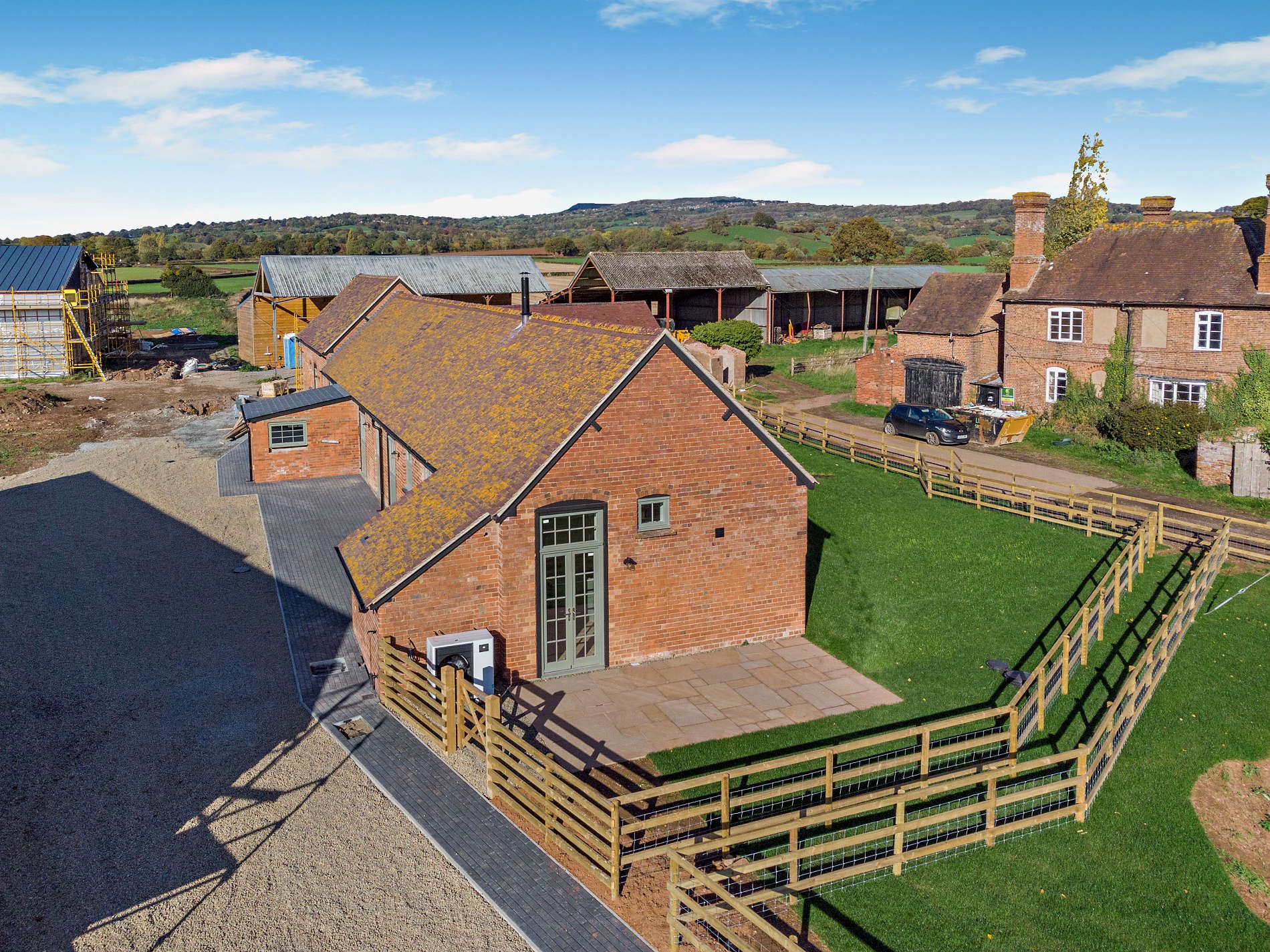 Converted brick barn with a gable, terrace and lawn