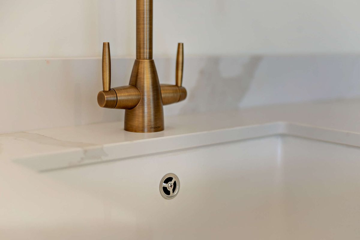 Brushed brass tap on marble