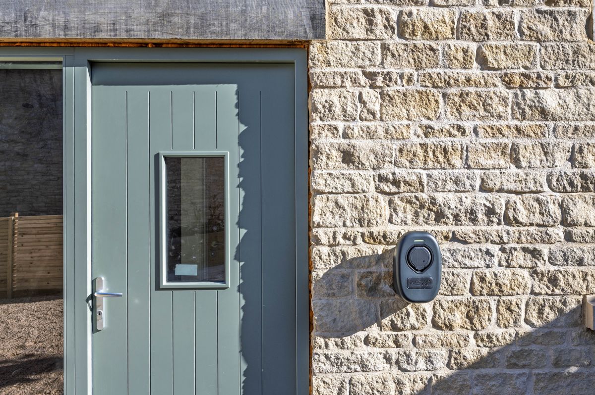 Sage green front door set in dressed Cotswold stone