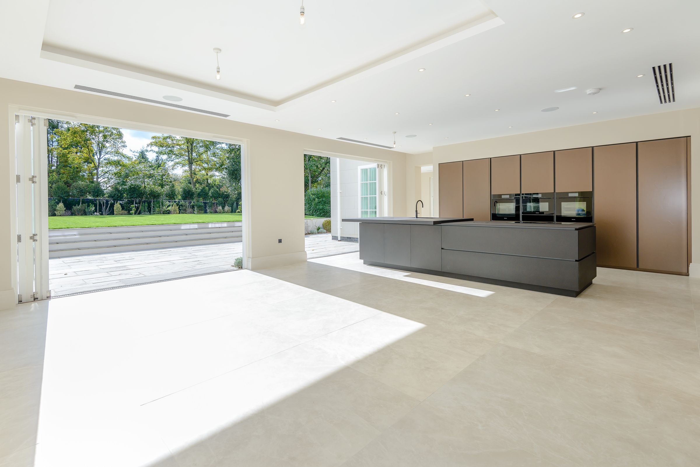 Open-plan kitchen with a glazed wall opening onto the garden